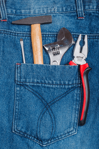 Photo d'une poche arrière de jean avec des outils glissés dedans
